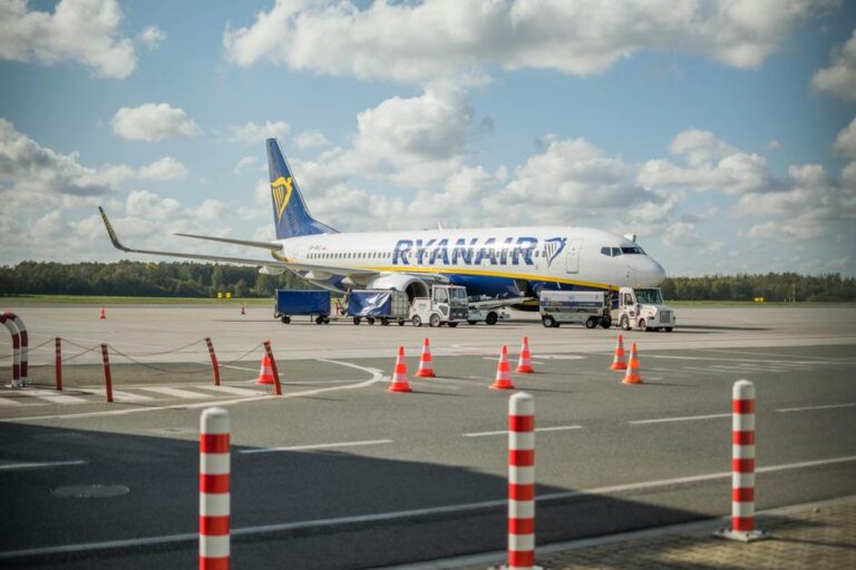 alt_text: Lotnisko we Wrocławiu, nowoczesny terminal i samoloty na tle niebieskiego nieba.